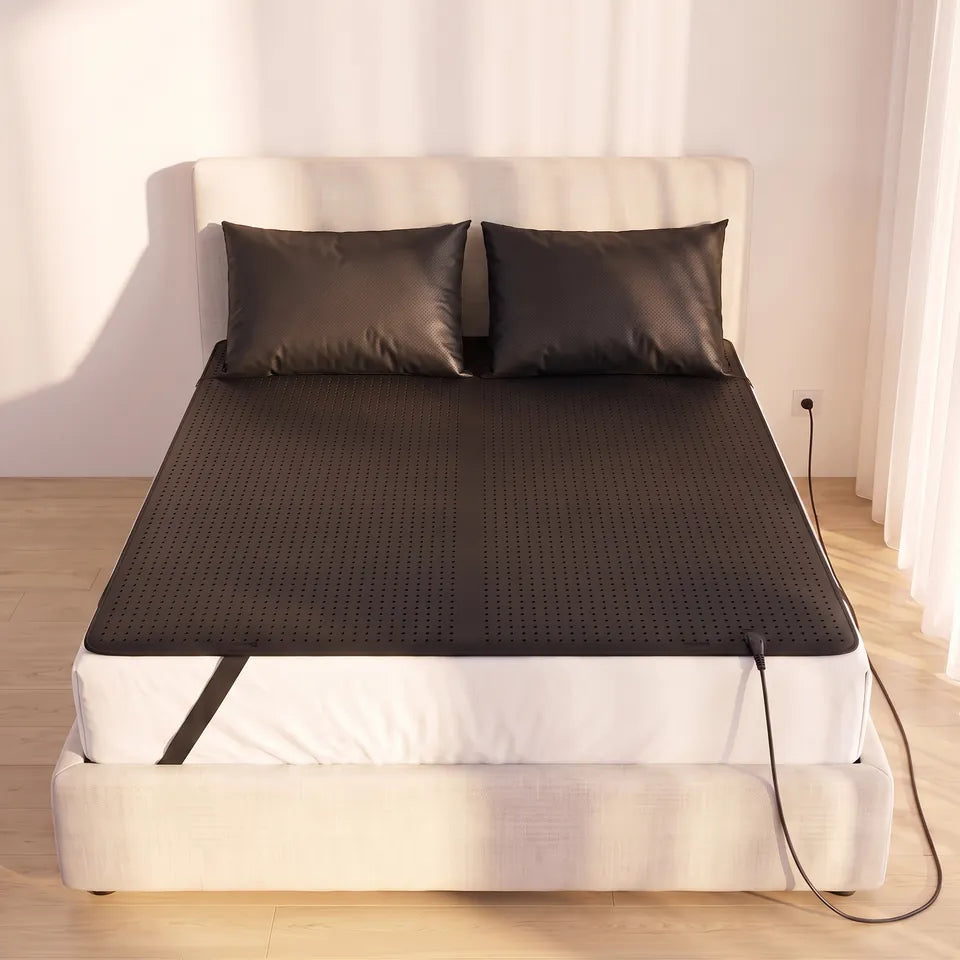 Una cama con la alfombrilla de conexión a tierra y las fundas de almohada de conexión a tierra