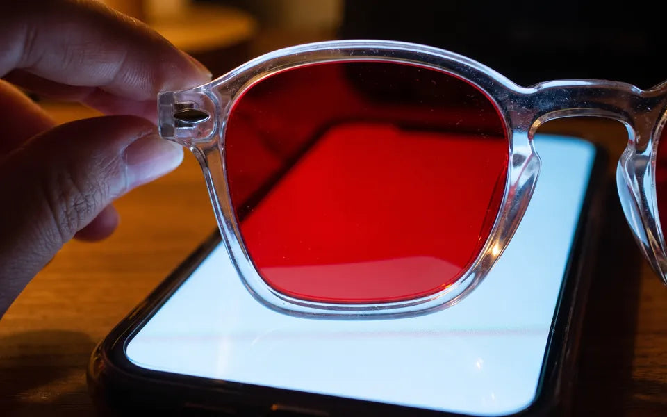 Una lente roja convirtiendo en roja la pantalla brillante de un teléfono